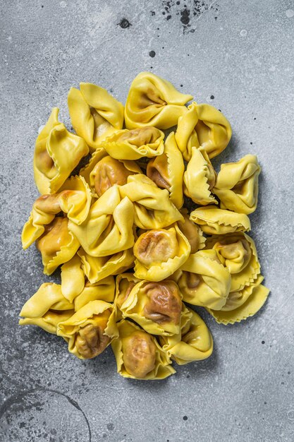 Ravioli cru cru com mussarela e tomate. Plano de fundo cinza. Vista do topo.