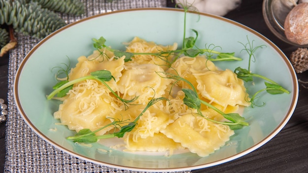 Ravioli italiano com queijo e hortaliças na placa azul.