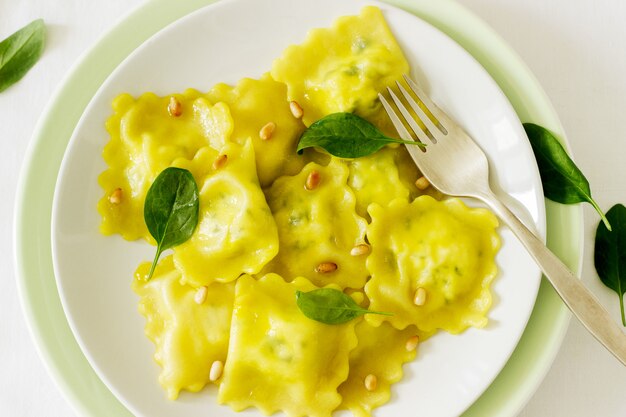 Ravioli mit Ricotta und Spinat, serviert mit Olivenöl und Pinienkernen