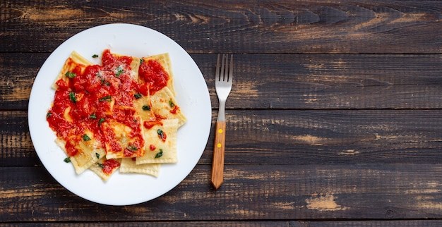 Ravioli mit Tomatensauce, Spinat und Parmesan. Gesundes Essen. Vegetarisches Essen. Italienische Küche.