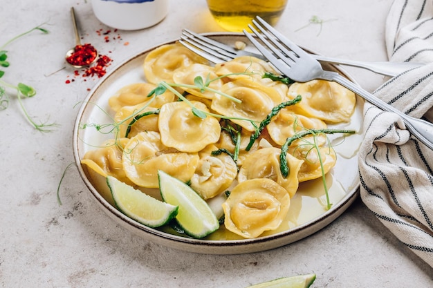 Ravioli de queso italiano con espárragos asados en salsa de mantequilla de limón con hierbas Enfoque selectivo