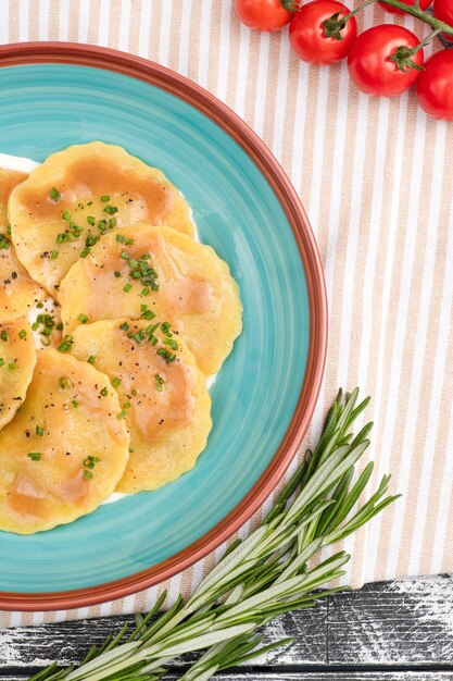 Ravioli ravioli italiano sobre una vista superior de fondo de madera blanca