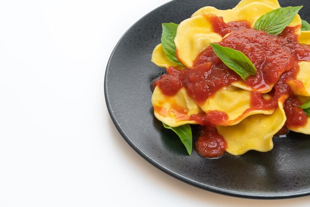 Ravioli con salsa de tomate y albahaca aislado sobre fondo blanco.