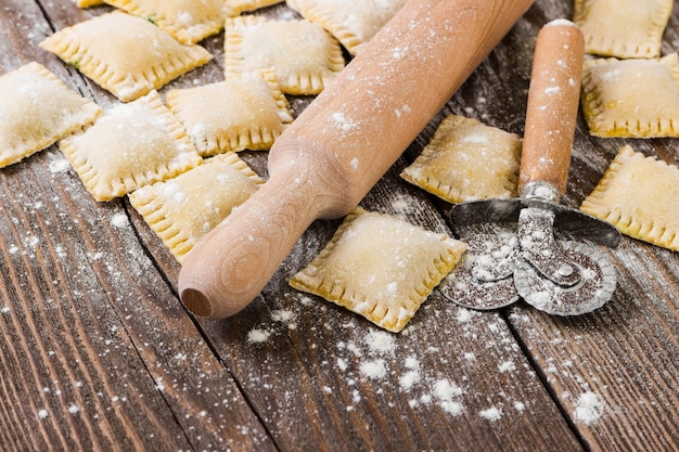 Raviolis crudos con espinacas y queso ricotta sobre fondo de madera