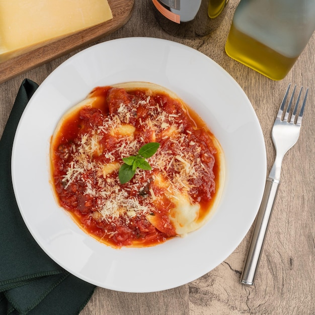 Foto raviolonis ou raviolis com molho de tomate sobre mesa de madeira