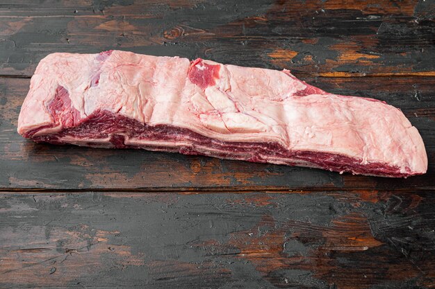 Raw Black Angus Marbled Beef Ribs-Set auf altem dunklem Holztischhintergrund mit Kopierraum für Text