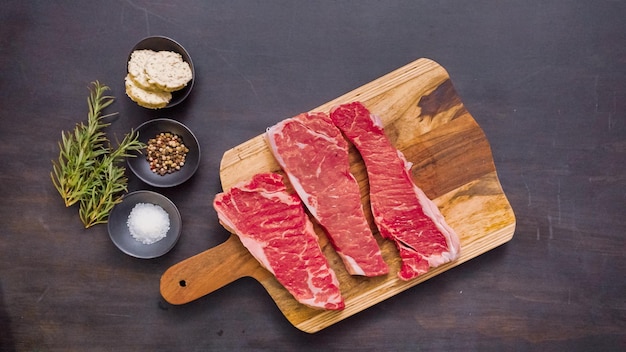 Raw New York Strip Steaks auf einem Holzbrett.