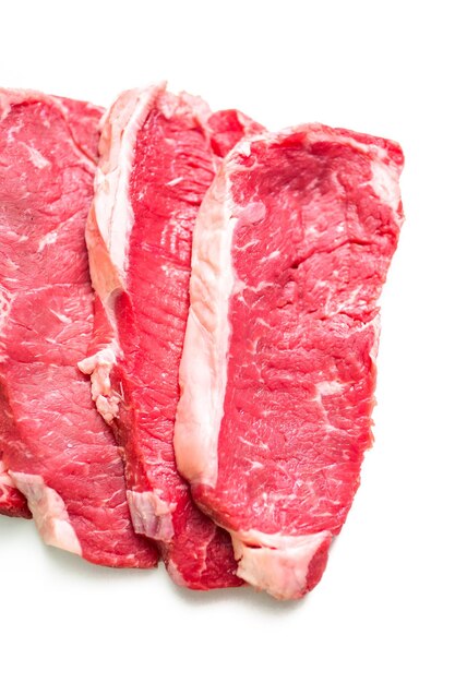 Raw New York Strip Steaks auf weißem Hintergrund.