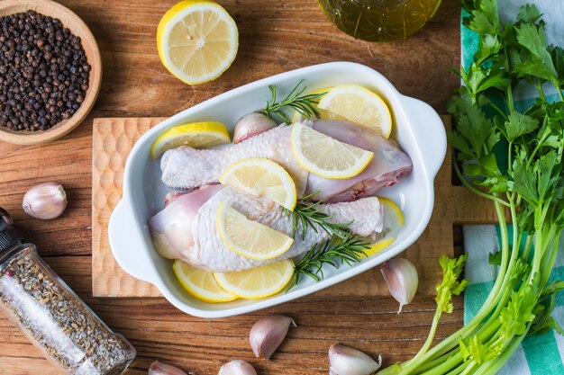 Raw ungekocht Hähnchenschenkel, Drumsticks auf Holzbrett, Fleisch mit Zutaten zum Kochen