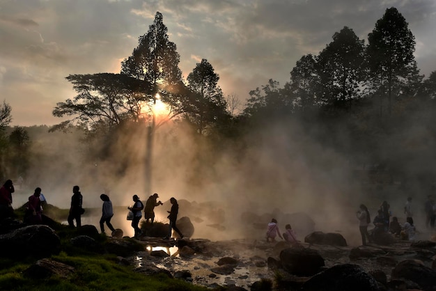 Rayo de luz dorada forma niebla de aguas termales en una mañana Tailandia