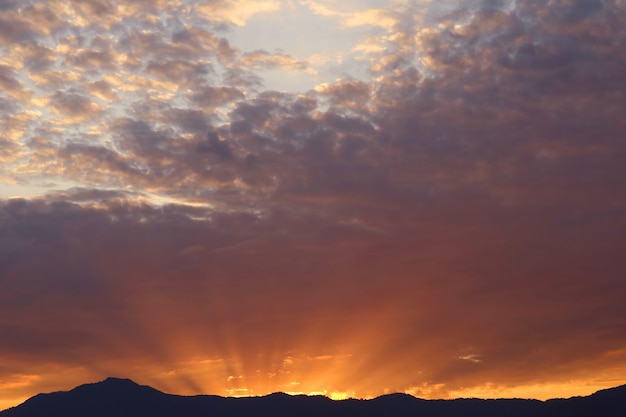 Rayo de sol del sol naciente brilla detrás de la montaña