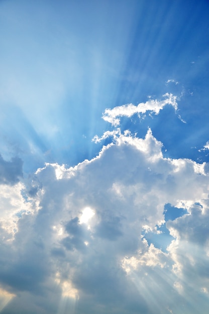 Rayo de sol a través de la bruma en el cielo azul, nubes con rayos de sol