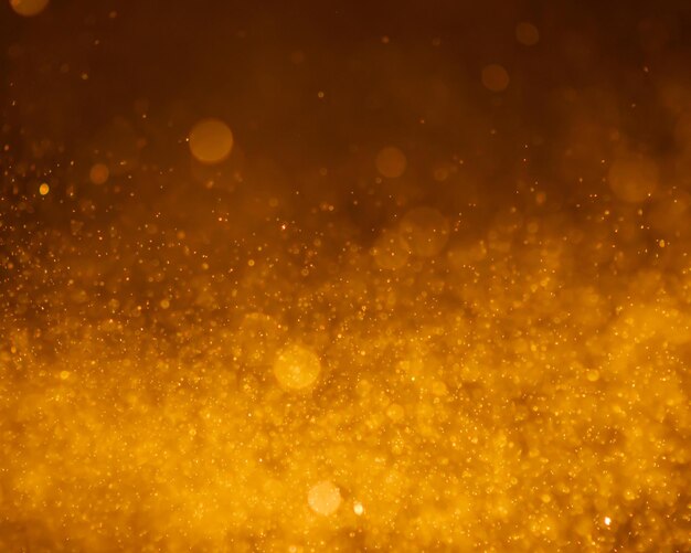 Foto los rayos de brillo dorado oscuro las luces con bokeh el fondo abstracto elegante las chispas de polvo en la explosión