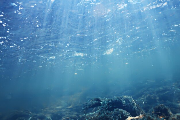 Los rayos del sol bajo el agua del océano azul de fondo, la luz del sol abstracto en el fondo de pantalla de agua