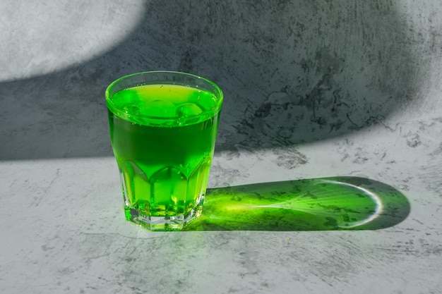 Los rayos del sol en una bebida verde. Limonada carbonatada refrescante de verano. Bebida carbonatada de estragón.