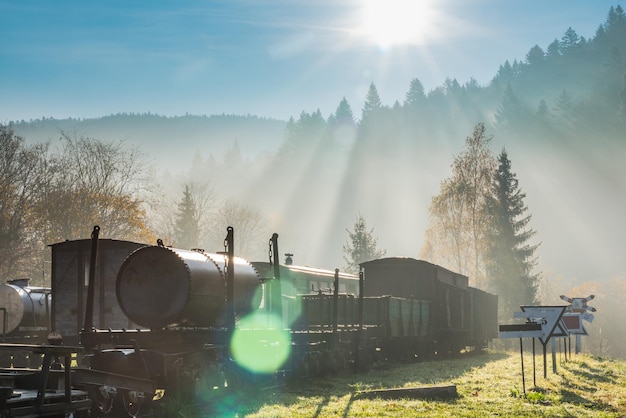 Rayos de sol y bengalas en la mañana brumosa en la estación de tren abandonada