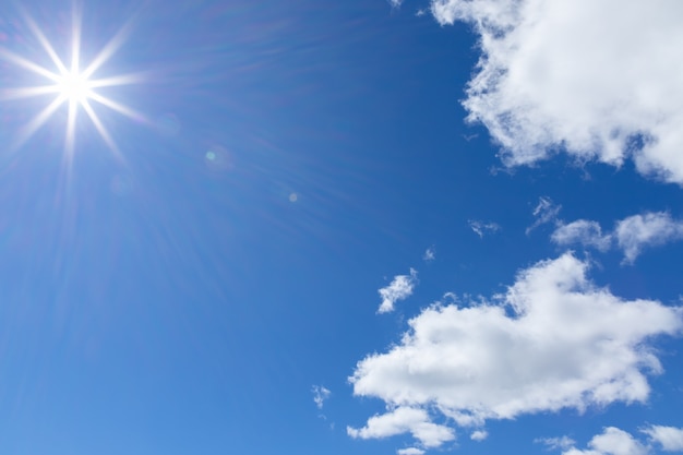 Los rayos del sol en el cielo azul con cúmulos.