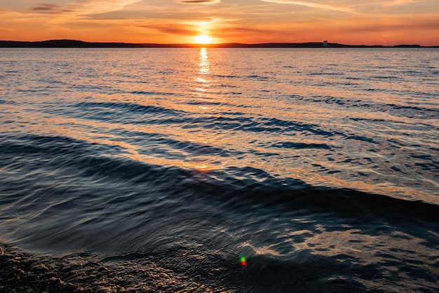 Los rayos del sol se reflejan en el agua al atardecer