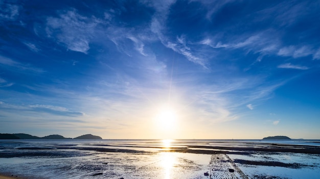 Los rayos del sol sobre el mar hermosas nubes con la puesta de sol sobre el mar claro horizonte marino sobre el cielo azul con sol brillo Naturaleza entorno cielo fondo