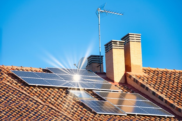 Rayos solares reflejados en los paneles solares en el techo de una casa.