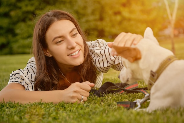 La raza de perro parson russell terrier está jugando en Green Park con su dueño en verano o al comienzo de