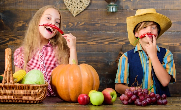 Razones por las que todos los niños deberían experimentar la agricultura Mercado agrícola Hermanos divirtiéndose Niños agricultores niña niño cosecha de verduras Granja familiar Niños presentando cosecha agrícola fondo de madera