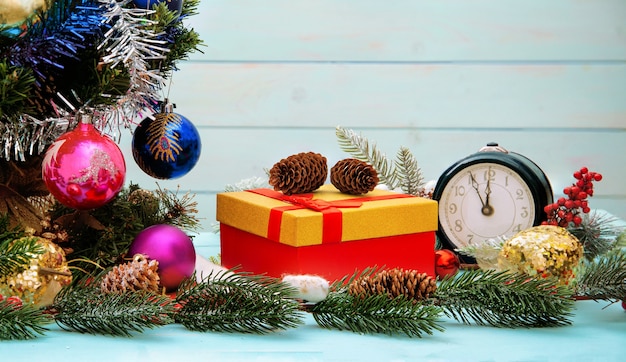 Árbol de año nuevo, reloj, regalo un árbol de navidad decorado en mesa de madera azul