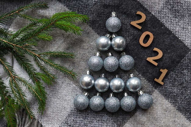 Árbol de bolas de Navidad de color plateado sobre una acogedora manta gris