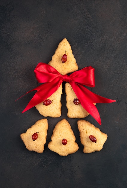 Árbol de Navidad abstracto hecho de galletas y un lazo rojo