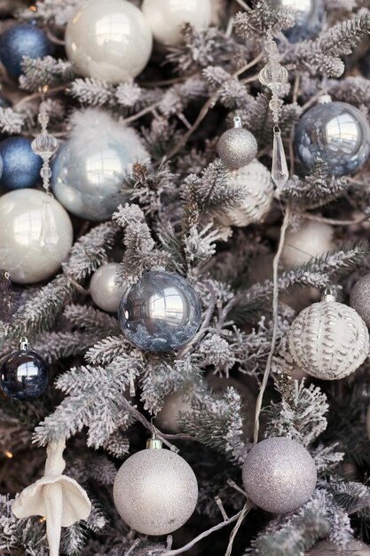 Árbol de Navidad con adornos plateados y azules.