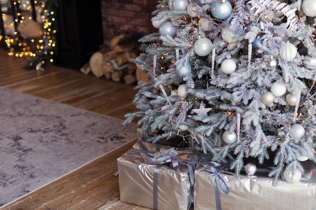 Árbol de Navidad con adornos plateados y azules.