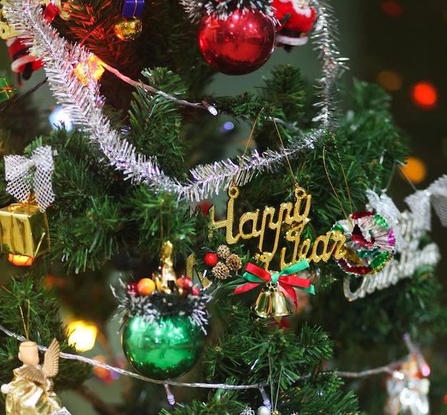 Árbol de Navidad artificial verde decorado con luces y juguetes navideños. De cerca