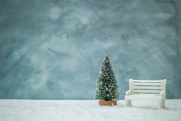 Árbol de navidad con un banco blanco.