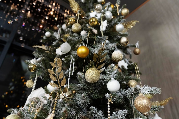 Árbol de Navidad bellamente decorado con guirnaldas y juguetes antes de las vacaciones