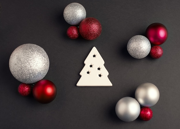 Árbol de Navidad blanco y bolas de Navidad de un color diferente sobre un fondo oscuro