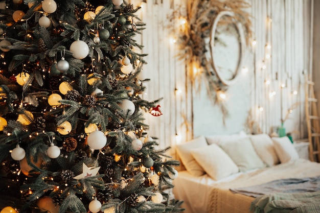 Árbol de Navidad con bolas blancas y guirnaldas con pared blanca rústica de madera