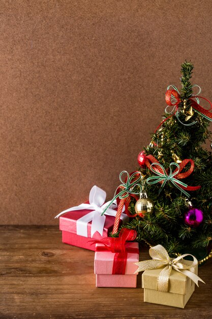 Árbol de Navidad y caja de regalo en el fondo de la mesa de madera