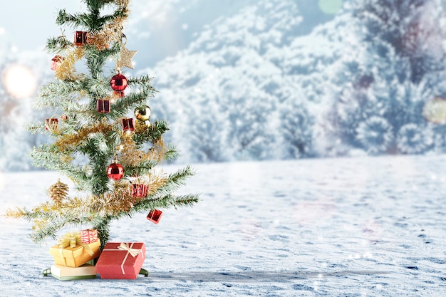 Árbol de navidad con caja de regalo en la nieve