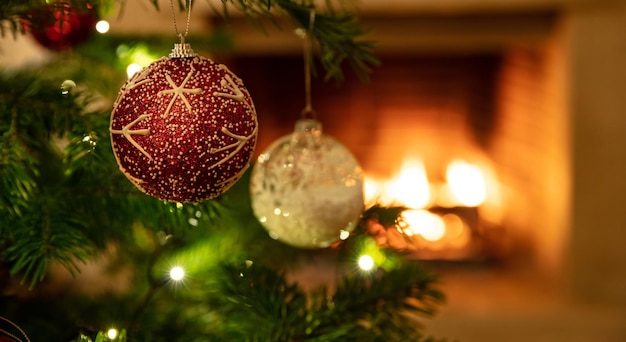 Árbol de Navidad de cerca en el fondo de la chimenea ardiente