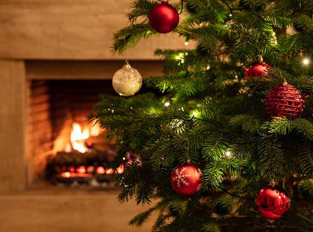 Árbol de Navidad de cerca en el fondo de la chimenea ardiente