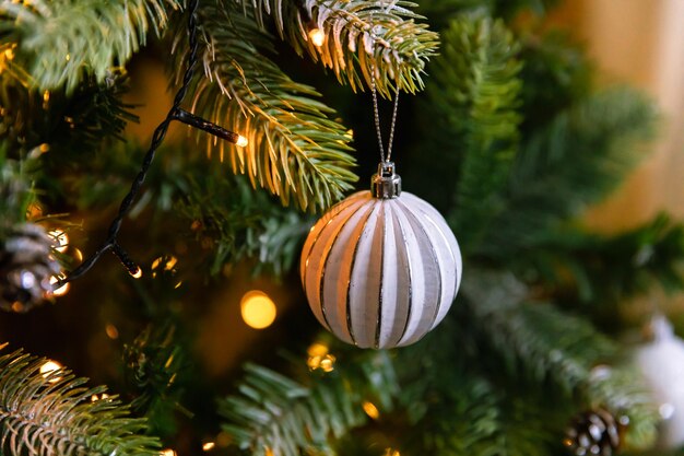 Árbol de navidad clásico decorado con adornos navideños con adornos de plata ...