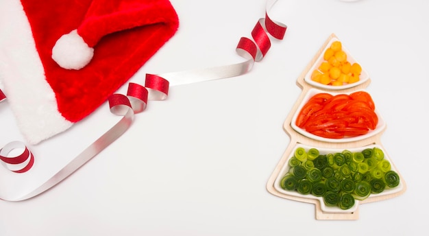 Árbol de Navidad, comida festiva para niños. Las verduras y frutas se cortan en un jarrón en forma.