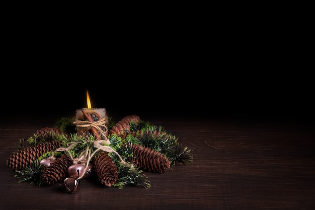 Árbol de Navidad y conos decorados con velas encendidas.