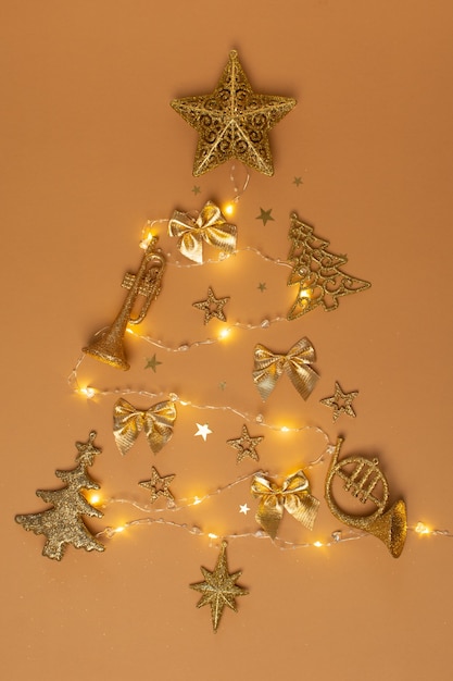 Árbol de navidad creativo dorado de decoraciones navideñas con luces en beige
