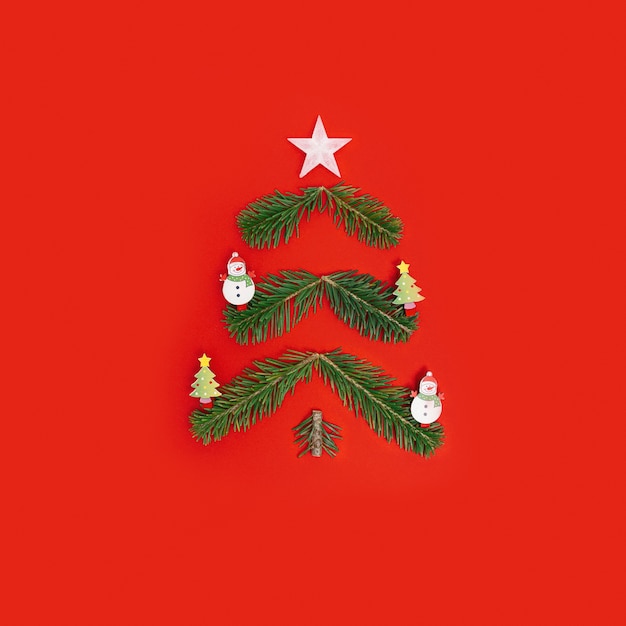 Árbol de Navidad creativo de ramas de pino abeto de año nuevo verde natural en estilo minimalista rojo