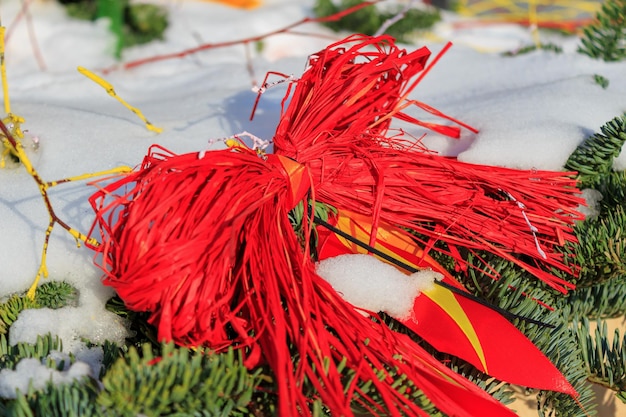 Árbol de navidad cubierto de nieve decorado con juguetes de paja