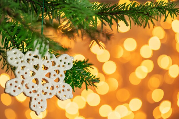 Árbol de Navidad y decoración navideña con copo de nieve en bokeh dorado