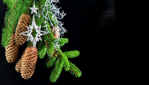 Árbol de Navidad con decoración plateada brillante sobre fondo negro. adornos festivos. concepto de tarjeta con espacio de copia