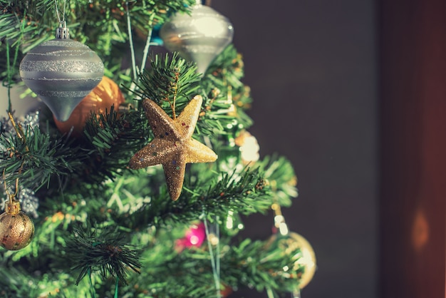 Árbol de Navidad decorado con adornos, adornos, burbujas, bolas y estrellas doradas.