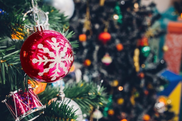 Árbol de Navidad decorado con adornos de colores sobre fondo borroso de luz bokeh brillante